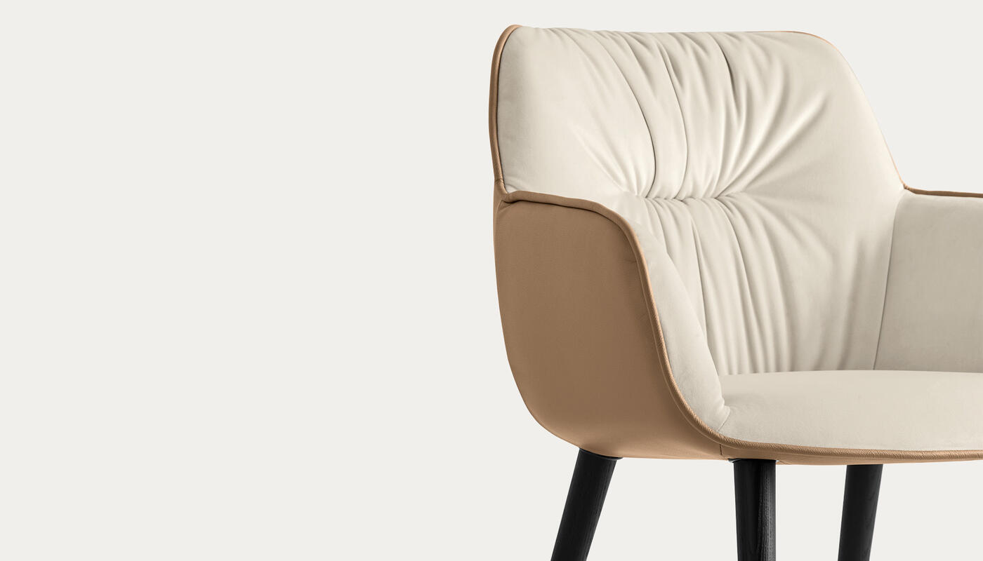 Cocoon: Two-tone armchair with plush seat and wooden legs